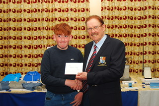 I don't know who these people are, but here's an alt text: Two people shaking hands at an award ceremony, holding a certificate.